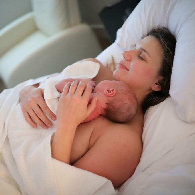 A mom holding her newborn in bed