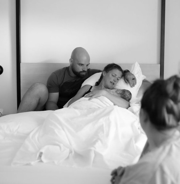 A mother holding her baby in her arms after a home birth