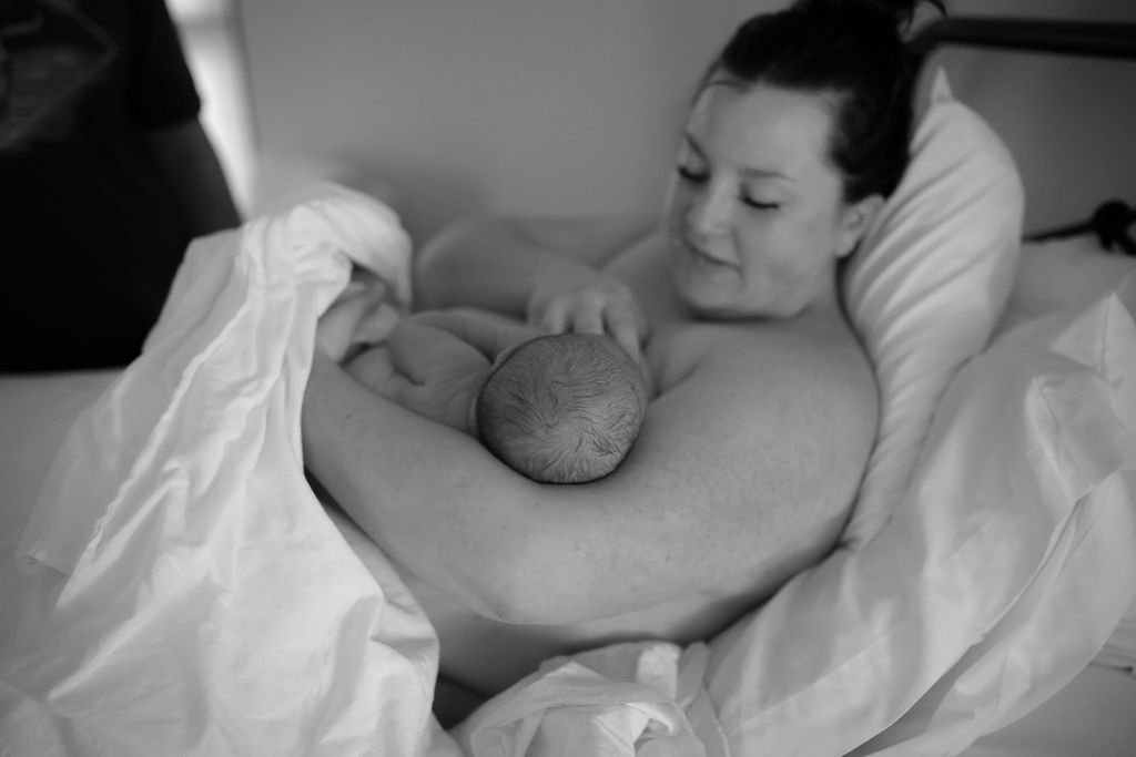A woman breastfeeding her child in bed