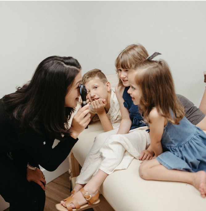 A pediatric nurse practitioner at an appointment with children