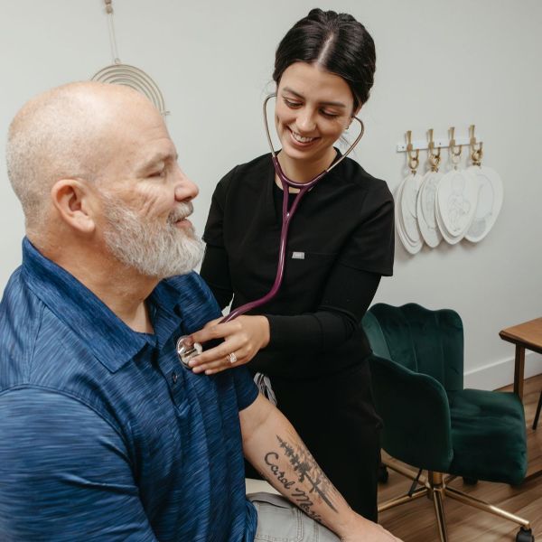 A men's health specialist using a stethoscope on a man